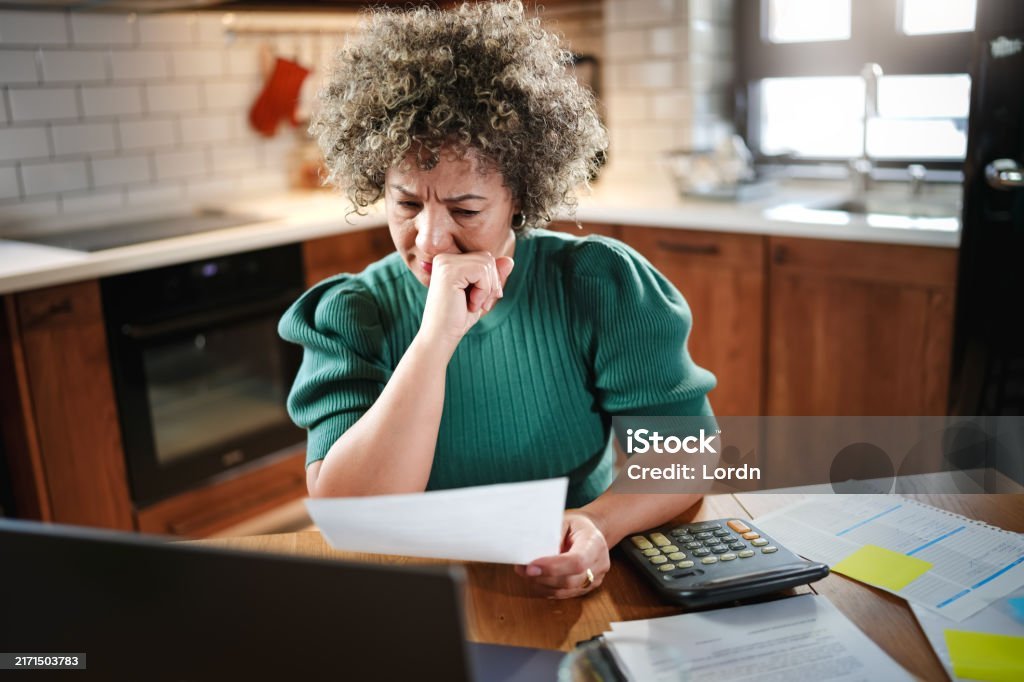 Pessoa preocupada olhando para contas e boletos financeiros procurando os erros que te mantêm no vermelho