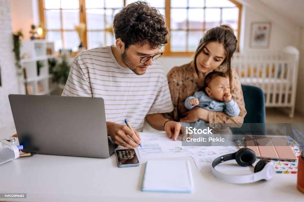 Família reunida à mesa analisando um orçamento, com calculadora e caderno, representando planejamento financeiro familiar.