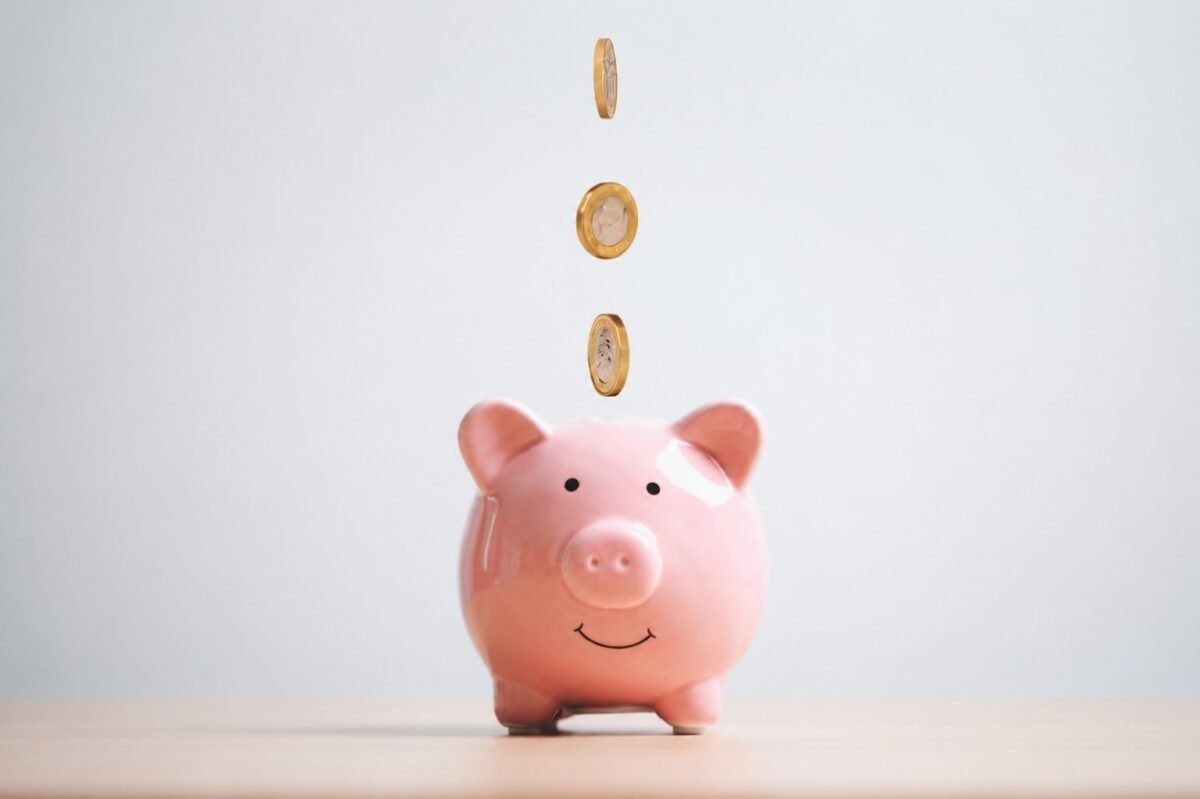 Ilustração de economia financeira: moedas caindo em um cofrinho de porco