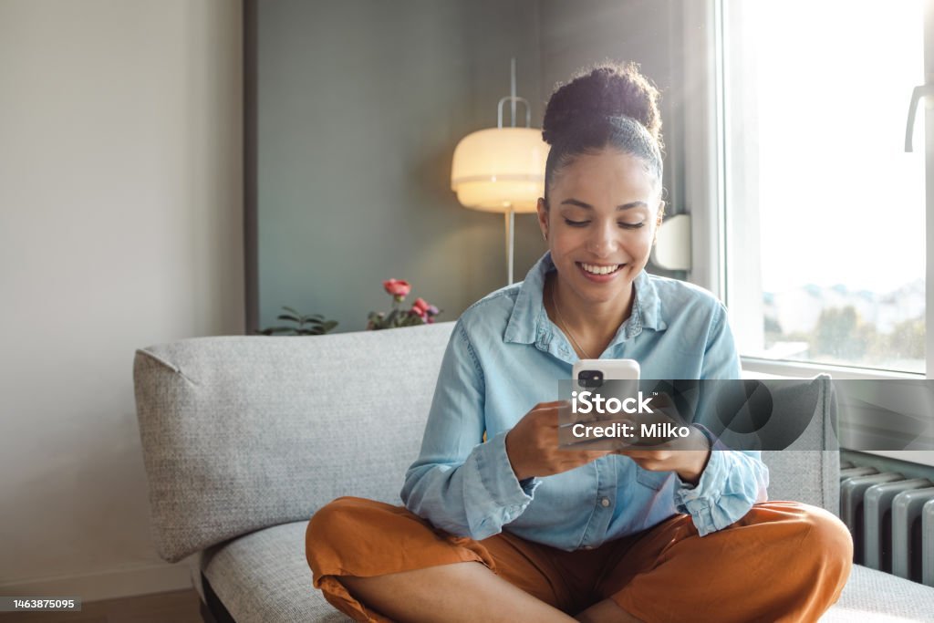 Pessoa feliz aprendendo a investir com pouco dinheiro usando o celular